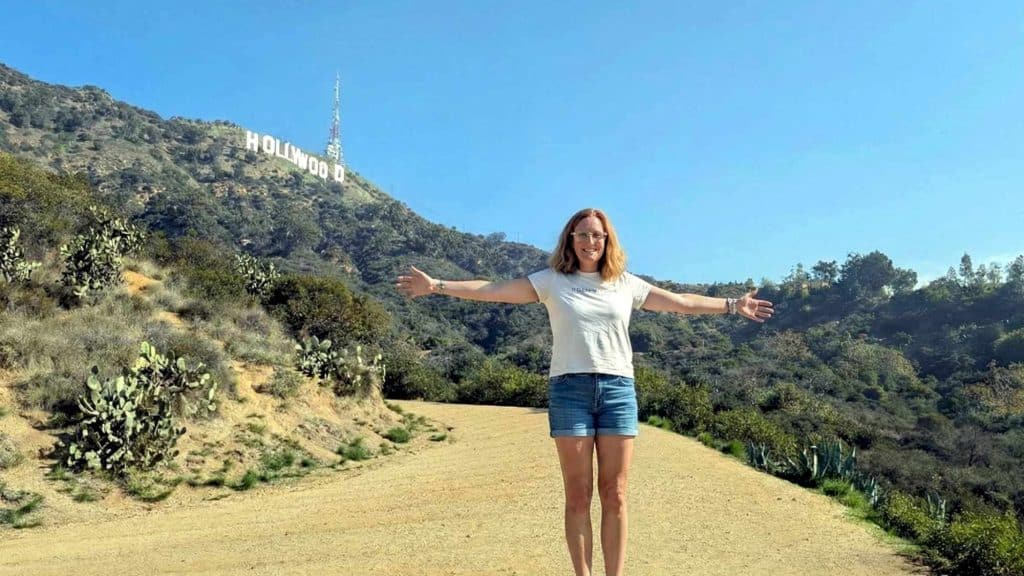Julia von Vista-Tours vor dem Hollywood Sign in Los Angeles mit ausgebreiteten Armen